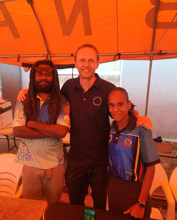 Three people standing and smiling.